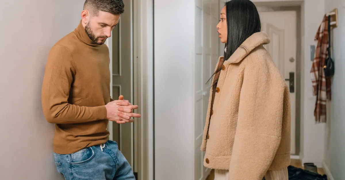A man and woman having a serious discussion indoors, portraying relationship tension.