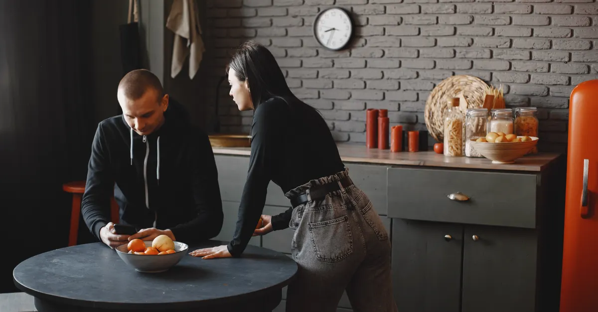 A couple having a conversation in a stylish kitchen, casually relaxed.