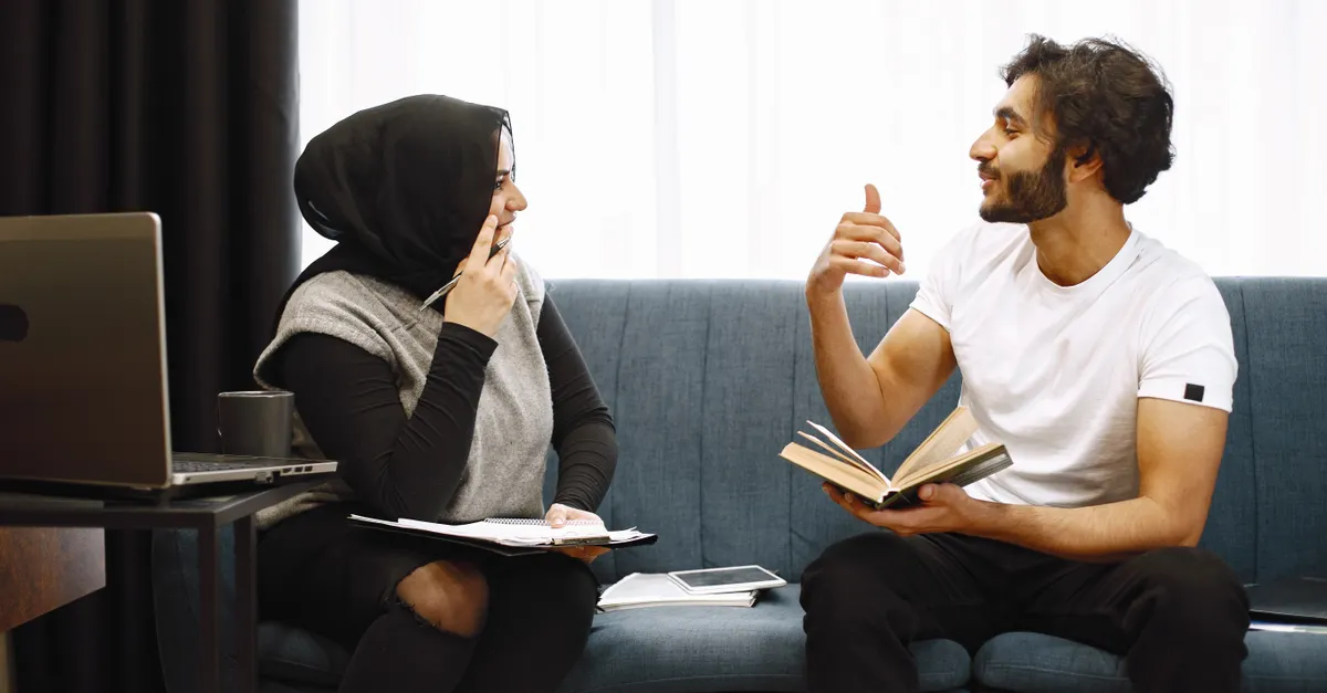 A man and woman talking warmly indoors, smiling at each other in a cozy room