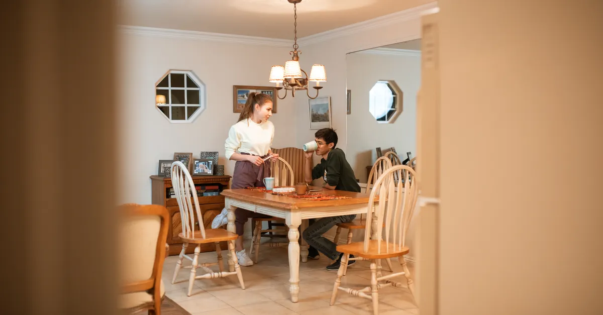 Young couple having a casual coffee chat at a dining table.